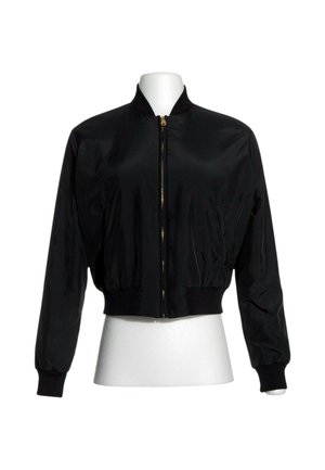 Veste bomber noire avec fermeture éclair sur le devant, col, poignets et taille côtelés, présentée sur un mannequin buste blanc.
