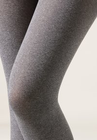 Šedé legíny vyrobené z měkké a elastické tkaniny. Design má hladkou texturu a přiléhavý tvar, elegantně zvýrazňující kolena a kontury.