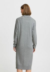 Grijze gebreide jurk met lange mouwen, voorzien van een hoge halslijn en een getailleerde pasvorm. Glad textuur en een knie-lange snit. Geen patronen of accenten.