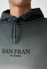 Hanorac cu gradient gri, dotat cu un glugă reglabilă, fabricat din material bicolor, având text îndrăzneț "SAN FRAN CALIFORNIA" în negru.