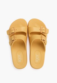 Yellow rubber sandals with two adjustable buckles, smooth texture, and a contoured footbed. Features the brand name "igor" on the sole.
