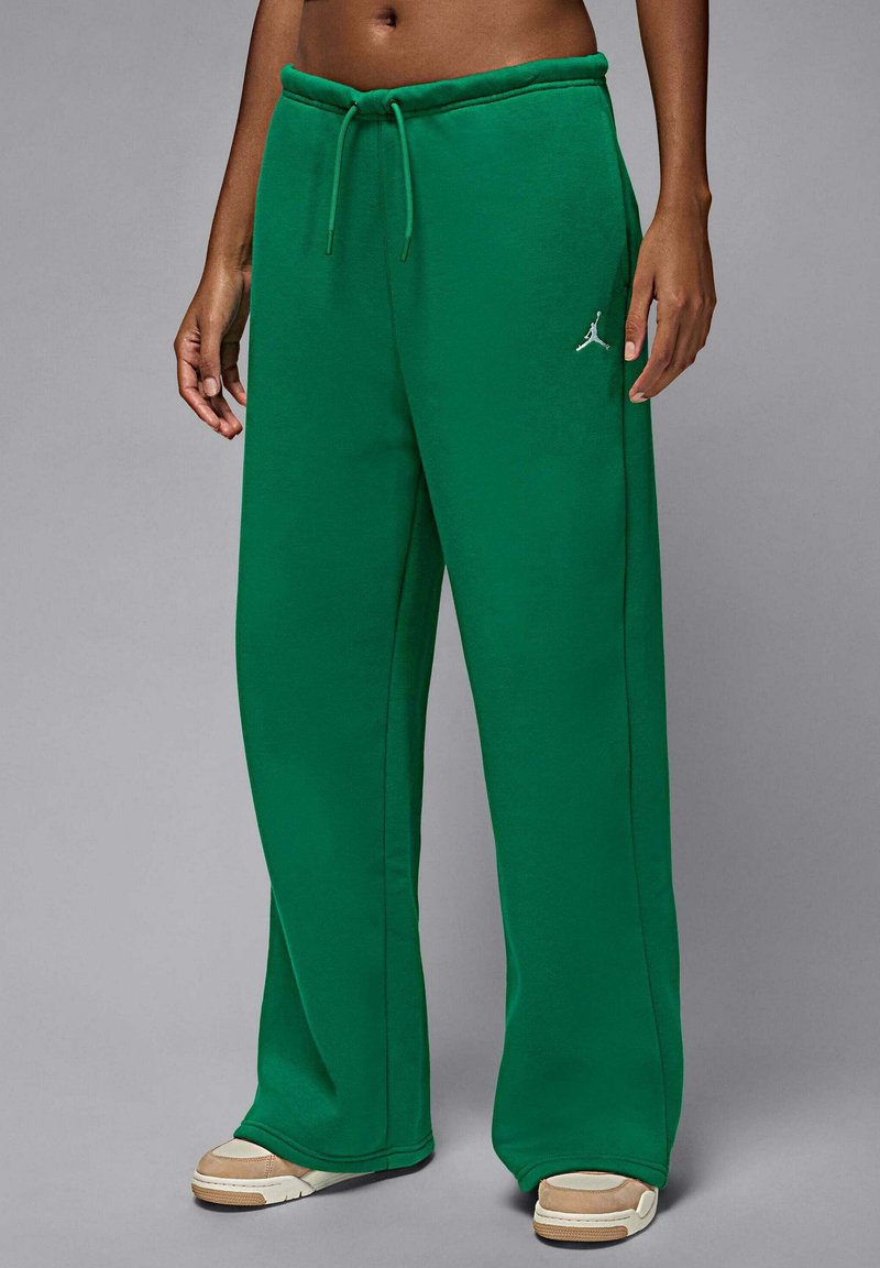Zielone spodnie dresowe z miękkiego materiału, z regulowanym sznurkiem w pasie, szerokimi nogawkami i małym białym logo Jordan na lewym biodrze.