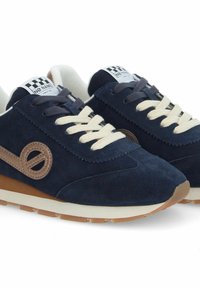 Baskets en daim marine avec lacets crème, présentant un accent de logo marron, un bout rond et une semelle en caoutchouc texturé.