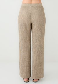 Beige, geplooide wijde broek met een textuurstof. Heeft een hoge tailleband en een losse pasvorm. Het materiaal heeft subtiele, gevarieerde tinten.
