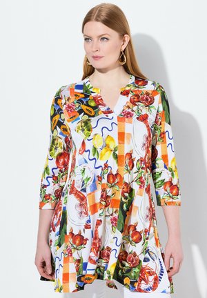 Tunique colorée à motifs avec des fruits, des fleurs et des formes géométriques. Confectionnée dans un tissu léger avec un col en V et des manches trois-quarts.