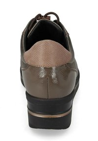 Scarpe da uomo marroni lucide con tacchetta posteriore testurizzata, colletto imbottito nero e suola nera spessa viste da dietro.