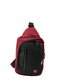 Compact rode en zwarte schouderrugzak met meerdere met rits afgesloten vakken en een klein figuur-sleutelhanger bevestigd aan een rits.