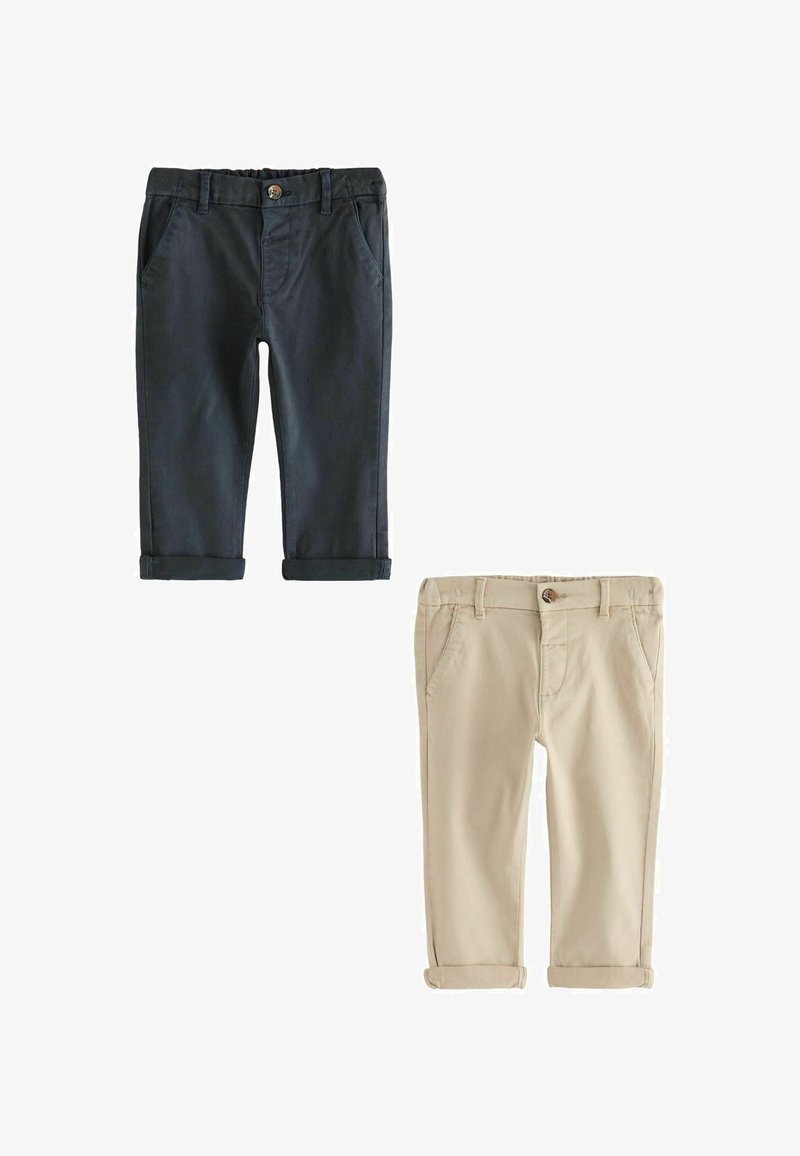 Dwie pary spodni z podwiniętymi mankietami: jedna ciemnoniebieska, druga beżowa. Obie mają boczne kieszenie i zapięcia na guziki, wykonane z gładkiego materiału.