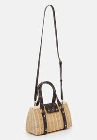 Sac en paille tissée avec une forme structurée, des poignées à motifs foncés et un rabat en cuir noir contrastant avec des accents métalliques.