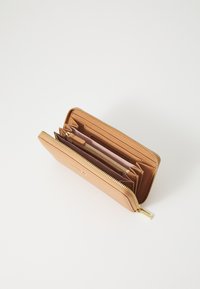 Portafoglio in pelle color tan con zip dorata, dotato di più scomparti e slot per carte, che mostra una superficie texturizzata e un design minimalista.