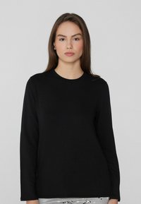 Czarny t-shirt z długim rękawem wykonany z miękkiego materiału, z okrągłym dekoltem i luźnym krojem. Brak widocznych wzorów lub akcentów.