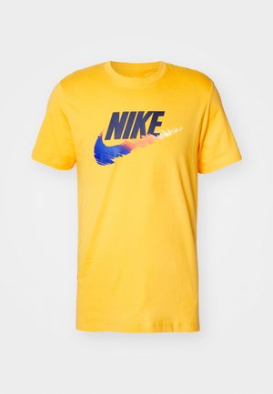 Camiseta de algodón amarilla con un logo negro de Nike y un diseño de swoosh en azul y naranja. Cuello redondo y mangas cortas.