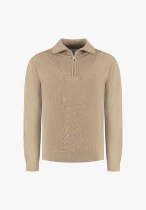 Beige gebreide trui met een hoge kraag en een halve rits, voorzien van een geribbelde textuur en een gedetailleerd ontwerp op de schouderpartij.