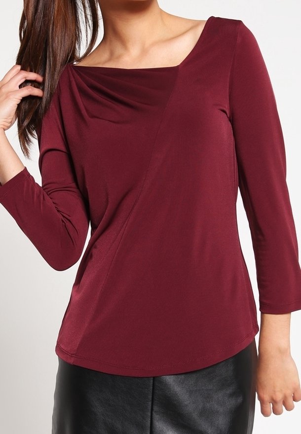 Burgundy long-sleeve top with a square neckline and draped front, featuring a soft, smooth texture and an asymmetric design.
