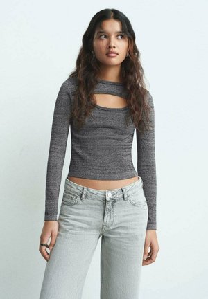 Top ajusté à manches longues en gris avec un motif texturé et un détail découpé au niveau du col, associé à un jean large gris clair.