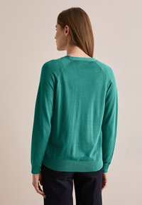 Teal gebreide trui, ronde halslijn, lange mouwen, geribde manchetten en zoom, zachte textuur, met raglan naden.
