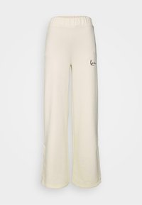 Kremowe spodnie w szerokim kroju z elastycznym paskiem w talii i bocznymi kieszeniami. Posiadają małe czarne logo po lewej stronie. Wykonane z miękkiego materiału bawełnianego.