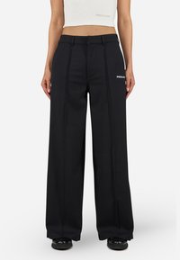 Black wide-leg trousers with pleats, made of a smooth fabric. Features a subtle logo on the front, and a classic waistband design.