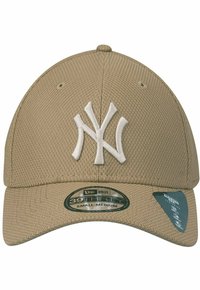 Khaki baseball cap made of textured fabric featuring a white embroidered "NY" logo, a curved brim, and a fitted design labeled 39Thirty, size small-medium.