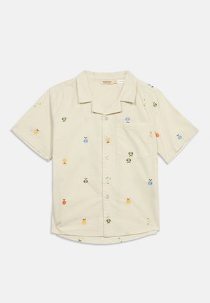Camicia beige a maniche corte con bottoni, colletto e piccoli motivi ricamati colorati di frutta, tra cui ananas e mele.