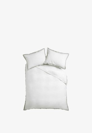 Weißes Doppelbett mit zwei Kissen, beide mit hellgrauem Rand, und einer passenden weißen Bettdecke, die oben rechts leicht umgefaltet ist.