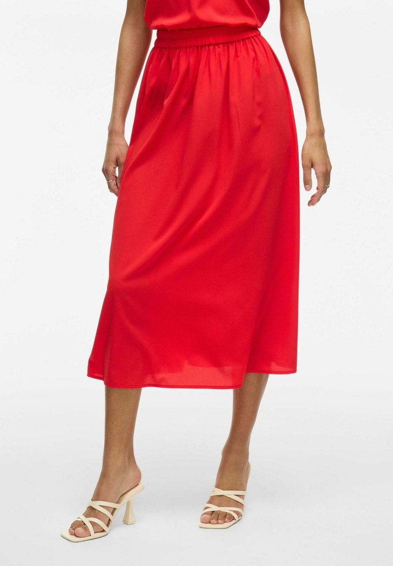Jupe midi rouge en satin avec une taille élastique et des poches latérales, présentant une coupe droite qui tombe juste en dessous des mollets.