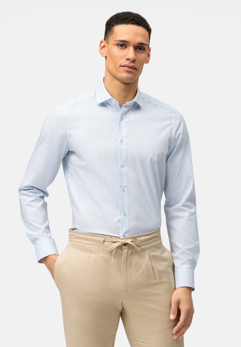 Hellblau gestreiftes Hemd mit Button-Down-Kragen, langen Ärmeln und Manschettenakzenten, kombiniert mit beigen Hosen, die einen Kordelzug haben.