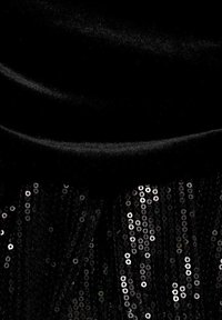 Tela de terciopelo negro con textura plegada en la parte superior, que se transforma en un fleco de lentejuelas negras en la parte inferior, creando un efecto detallado en capas.
