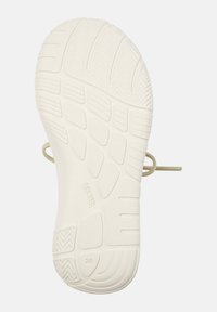 Gummisåle, off-white farge, med teksturerte tråder, fleksible spor og en lett snor detalj festet. Merket med "CAMPPER" og størrelse "28."