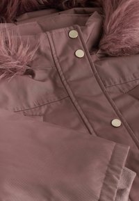 Støvet rosa parka med faux firkrave, metallisk trykknapper, quiltet tekstur og to frontlommer. Blødt, letvægtsstof.