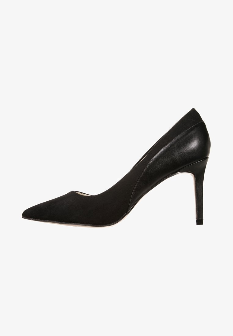 Escarpin noir à talon haut avec bout pointu, dos en cuir et talon aiguille fin présenté de profil sur fond blanc.