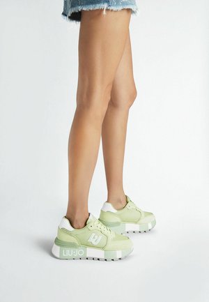 Sneakers verde chiaro con pannelli in rete, dettagli bianchi e suola piattaforma. Presentano un marchio sul lato e una finitura testurizzata.