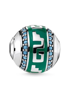 Srebrna kula z zieloną emaliowaną opaską ozdobioną geometrycznymi wycięciami, obramowana z każdej strony małymi turkusowymi kamieniami.