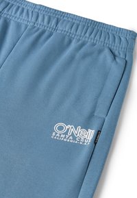 Hellblaue Sweatpants mit elastischem Bund, ausgestattet mit einem weißen, gestickten „O'Neill“-Logo und einem Etikett an der Seite. Weicher Stoff.