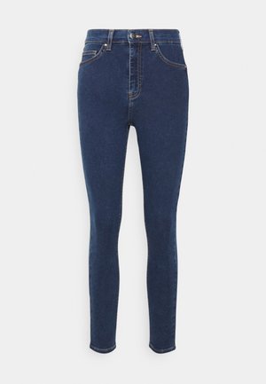 Jeans skinny de cintura alta em denim azul escuro. As características incluem um design de cinco bolsos, costura clara e fechamento com botão.