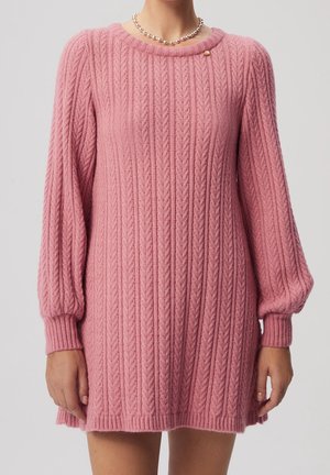 Roze gebreide jurk met een ribbeltextuur, ronde halslijn en lange pofmouwen. Kenmerkt zich door een kleine gouden accent bij de kraag.