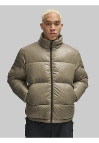 Olive roheline voodriga jakk kõrge kaelusega, lukuga sulgemine ja tikandiga disain. Omab küljetaskuid ja sujuvat, läikivat tekstuuri.