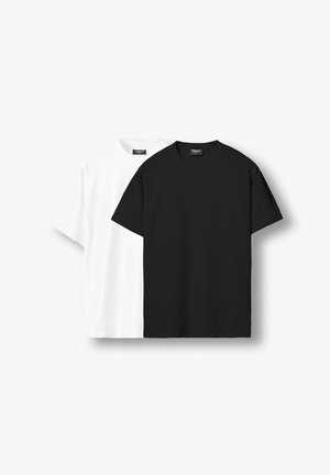 Fekete-fehér rövid ujjú, kerek nyakú pólók látható márkajelzésekkel, tiszta fehér háttéren kiállítva.