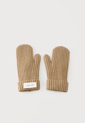 Paire de moufles en laine beige avec texture côtelée et poignets repliés, un poignet comportant une petite étiquette en tissu blanc.