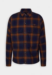 Marinblå och orange rutigt skjortjacka i flanell, med knappstängning fram, två bröstfickor och en klassisk kragdesign.