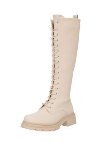 Botas de cuero beige hasta la rodilla con suela gruesa, con un cierre de cordones en la parte frontal, puntera redonda y un tirador en la parte superior.