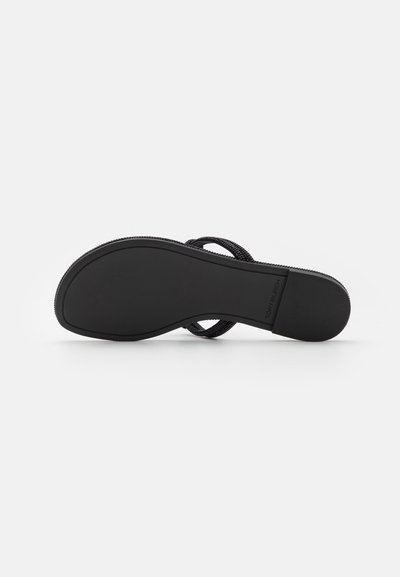Tongs noires avec une sangle en tissu texturé. Dotées d'une semelle en caoutchouc lisse avec une adhérence décorée, garantissant la stabilité lors de la marche.