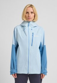 Giacca impermeabile azzurro chiaro con zip, cappuccio regolabile e maniche in blu scuro a contrasto. Presenta una tasca sul petto e un dettaglio con logo.