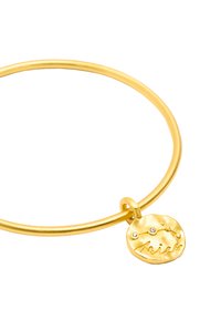 Bransoletka w odcieniu złotym o gładkim, okrągłym wzorze, z okrągłym charmem wygrawerowanym napisem "Baran" oraz trzema małymi osadzonymi kamieniami.