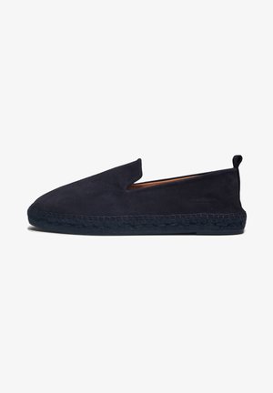 Zapato slip-on de ante en color navy con punta redonda, apertura lateral elástica y textura trenzada en la suela. Marca mínima en el lateral.