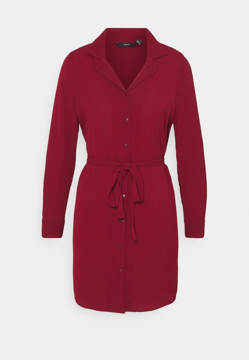 Robe rouge à manches longues, boutonnée, avec col et ceinture nouée à la taille sur fond blanc.