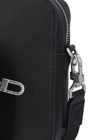 Borsa sintetica nera con texture, dotata di hardware argentato, chiusura con zip e una tracolla removibile con moschettone e dettagli cuciti.