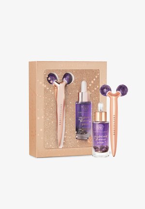 CrystalLove Geschenkeset mit einem lila Stein-Gesichtsroller mit roségoldenem Griff und zwei lila Serumfläschchen in einer glitzernden goldenen Box.