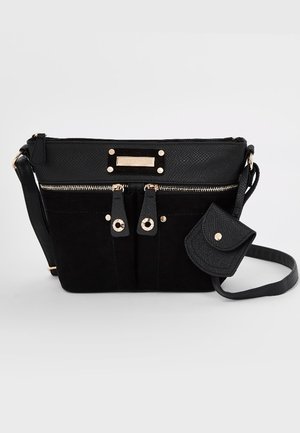 Bolso negro de bandolera con múltiples bolsillos con cremallera, dos correas frontales con botones de presión y un pequeño monedero adjunto a una correa.