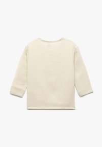 Top largo de manga larga en beige claro con cuello redondo. Tejido suave y texturizado con costuras mínimas y un corte holgado. Vista trasera mostrada.